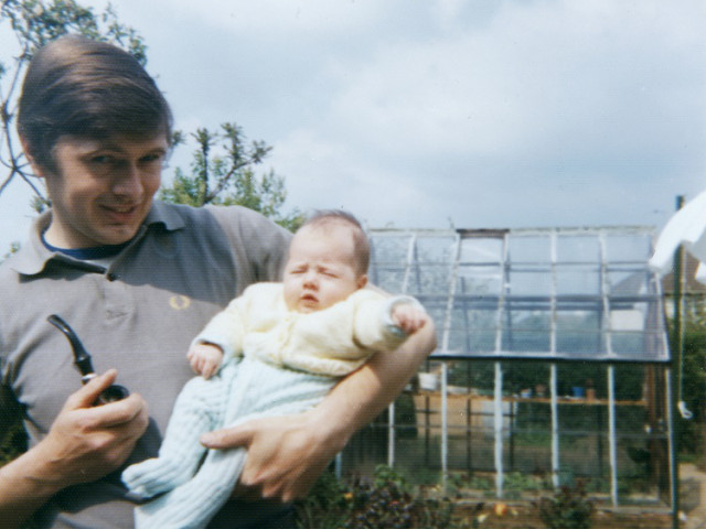 historisches Foto, auf dem Mann sein Baby auf dem Arm hält